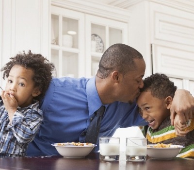 Father Kissing Kids at Breakfast